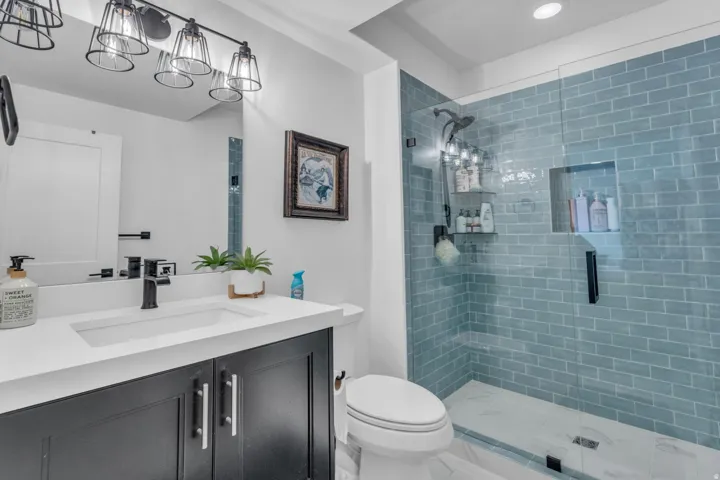 Vanity with a white countertop and undermount sink, dark cabinetry, and black faucet