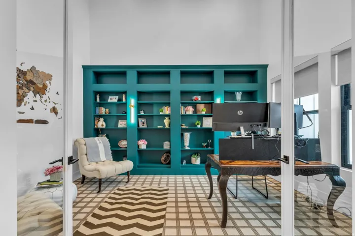 Built-in shelving with integrated lighting, glass panel doors, and patterned flooring