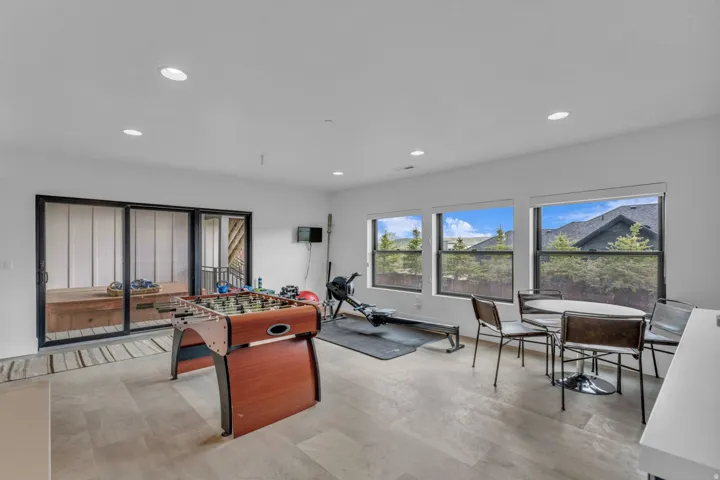 Spacious room with light wood-finish flooring, recessed lighting, and multiple windows