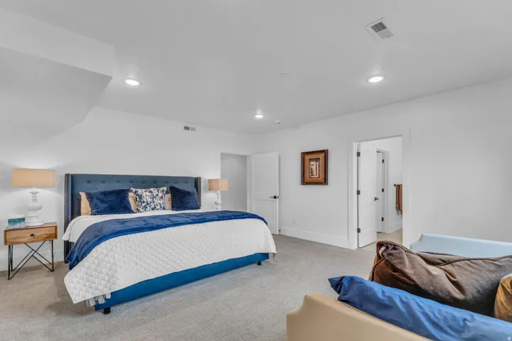 Recessed ceiling lighting, light-toned carpeting, white walls, and white trim throughout