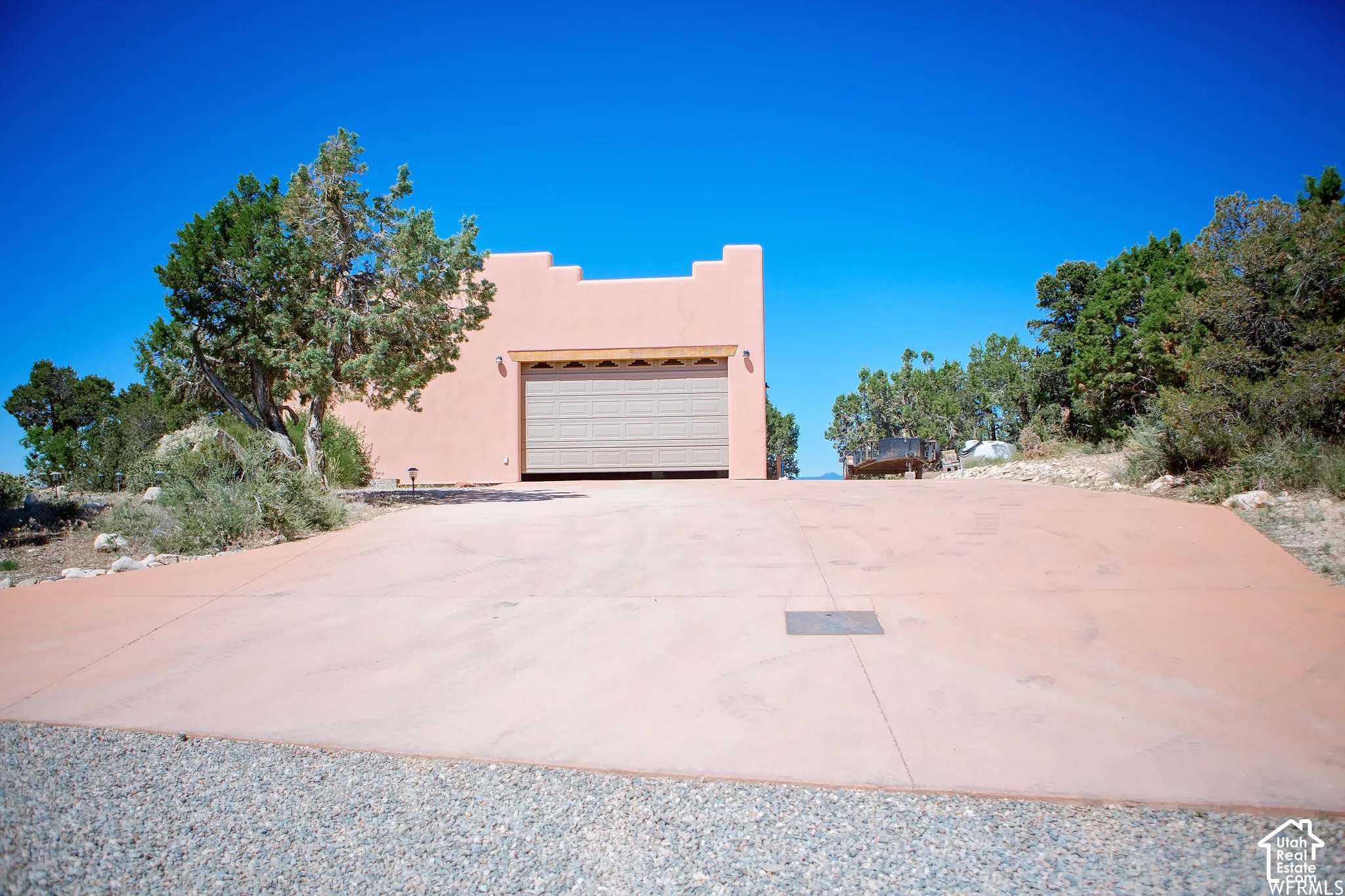 Southwestern architectural style, stucco exterior finish, attached garage, paved driveway, natural landscaping
