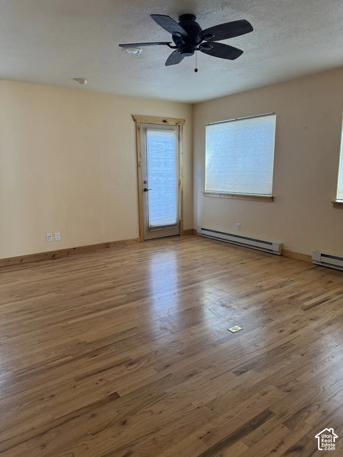 Wood-finish flooring throughout, complemented by a ceiling fan with integrated lighting