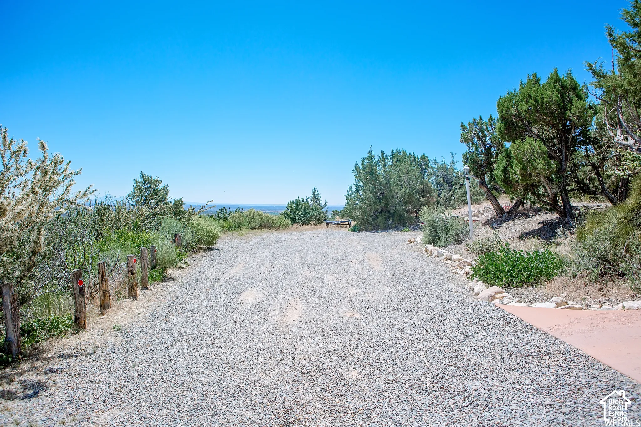 Gravel driveway with natural landscaping and distant scenery