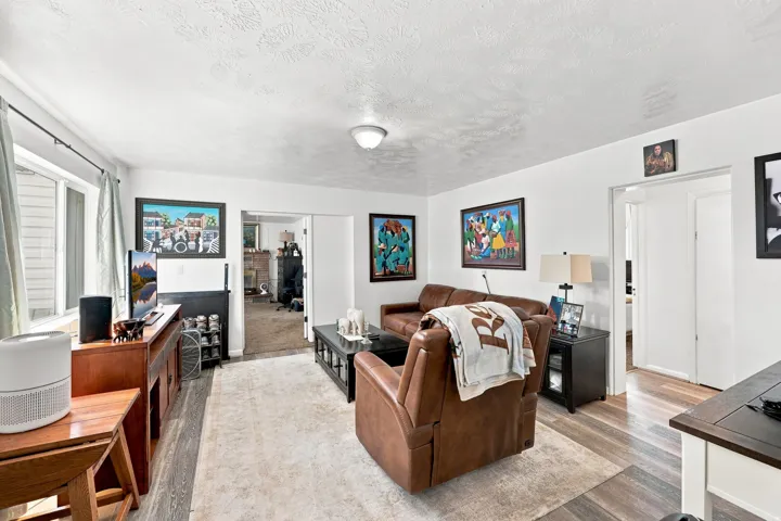 Wood-finish flooring, white walls, and a window with blinds