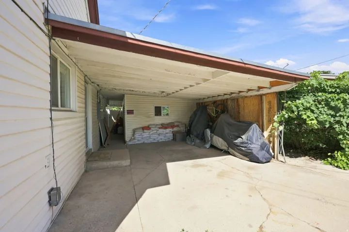 Covered carport with concrete flooring and direct access to the interior