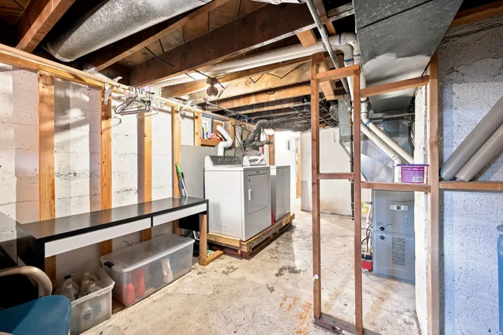 Utility area featuring a laundry appliance pair and a built-in workbench