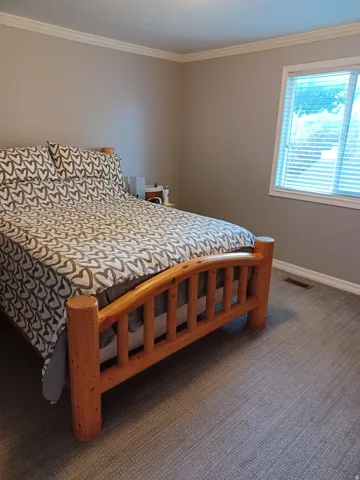 Neutral tone walls with window with blinds, and textured carpeting