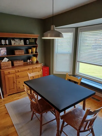 Hardwood flooring, painted walls, and multiple windows with blinds