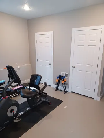 Light gray wall paint, two white paneled doors, and recessed ceiling lighting
