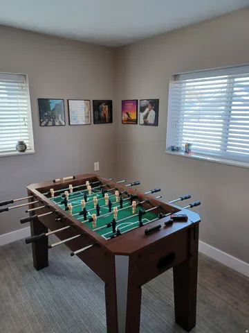 Carpeted room with neutral wall tones and two windows featuring blinds