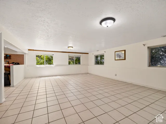 Tiled flooring, multiple windows, two flush-mount ceiling lights, and white wall finishes