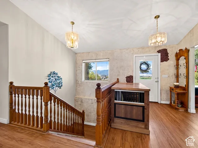 Wood-finish flooring throughout, solid wood staircase with balusters, and front entry