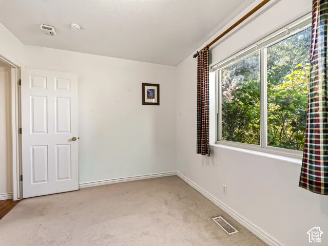 Front bedroom with wall-to-wall carpeting and a multi-pane window with a white frame