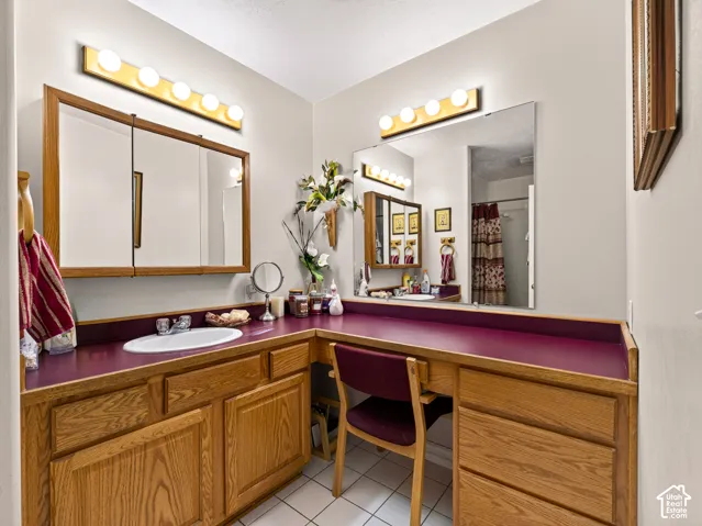 2nd bathroom with dual vanity, wood-finish cabinetry, integrated single-basin sink, and built-in makeup desk