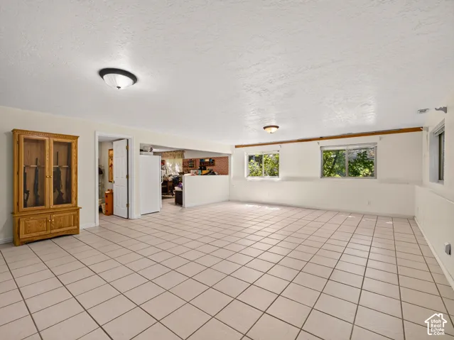 Expansive tiled flooring throughout, multiple windows, and a recessed ceiling light fixture