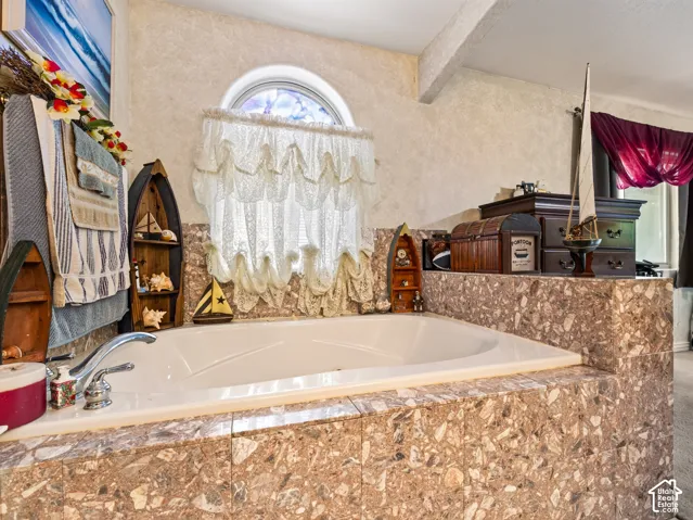 Built-in soaking tub featuring a tiled surround and chrome fixtures