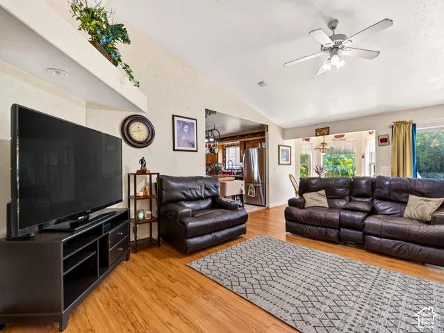Family room with LVP flooring, vaulted ceiling, recessed lighting, and a ceiling fan with integrated lighting