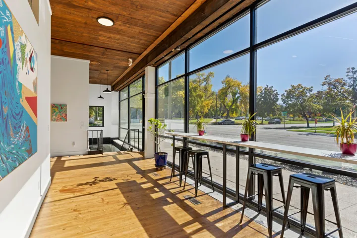 Expansive window wall, wood-finish flooring, wood ceiling, built-in counter seating, and recessed lighting