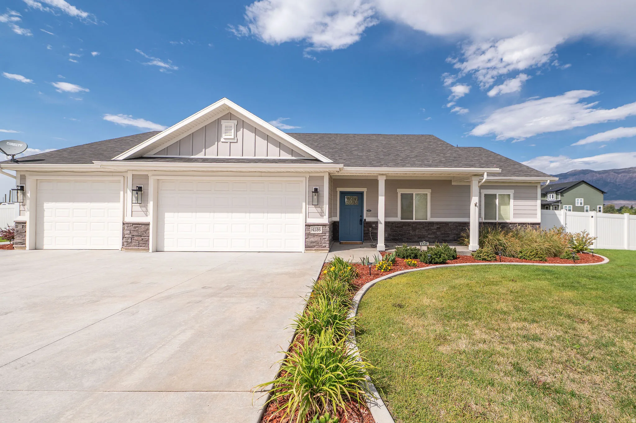 Siding exterior with stone accents, covered front porch, and a three-car garage