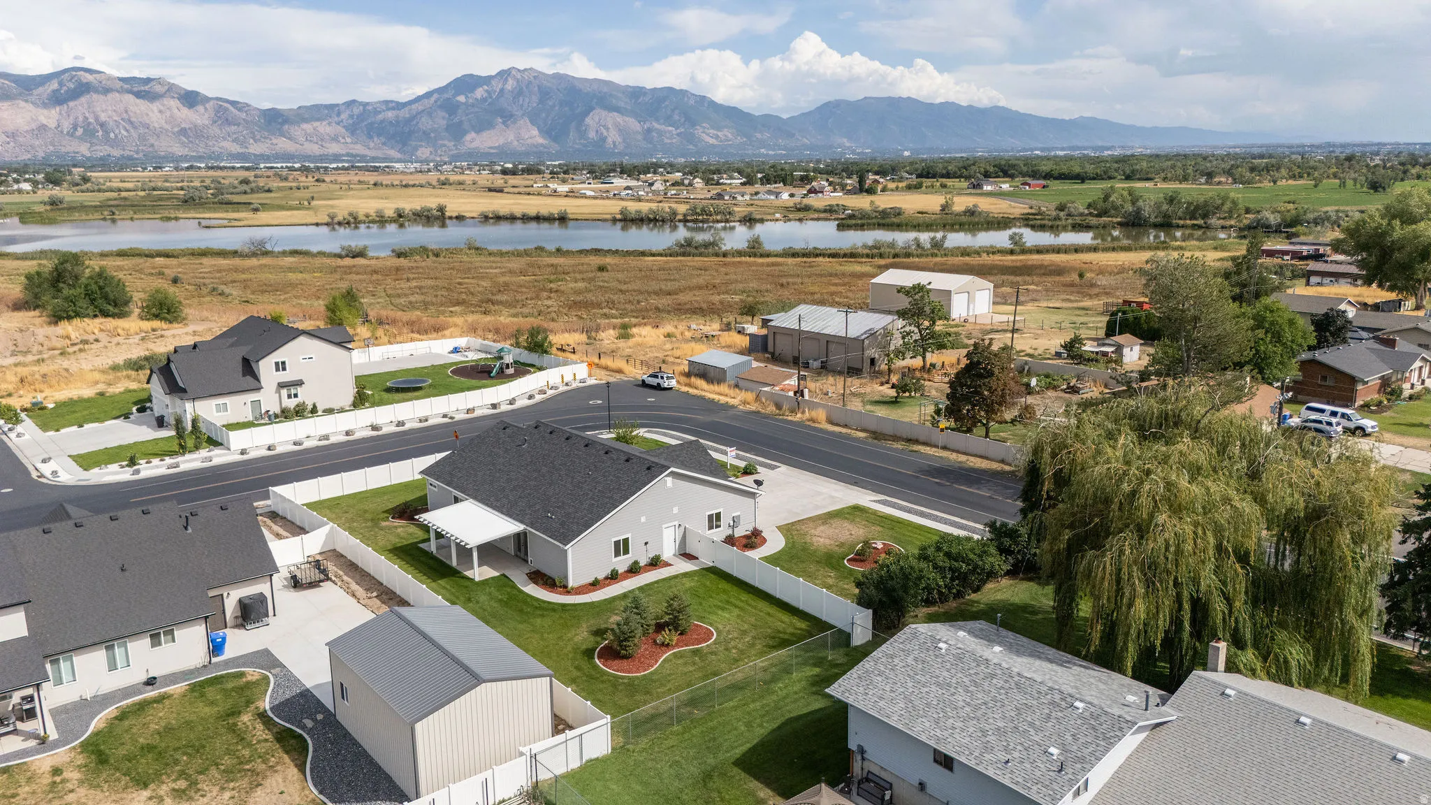 Fenced backyard with established landscaping, detached auxiliary structure, and mountain backdrop