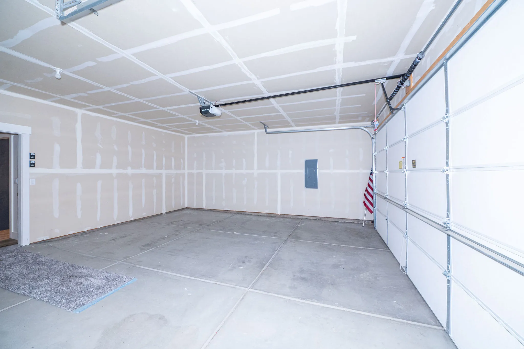 Spacious garage with concrete flooring, automatic garage door opener, and interior access
