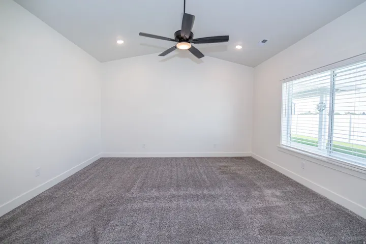 Vaulted ceiling with an installed ceiling fan and recessed lighting