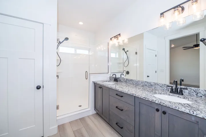 Dual vanity with stone-finish countertop, undermount sinks, and matte black fixtures