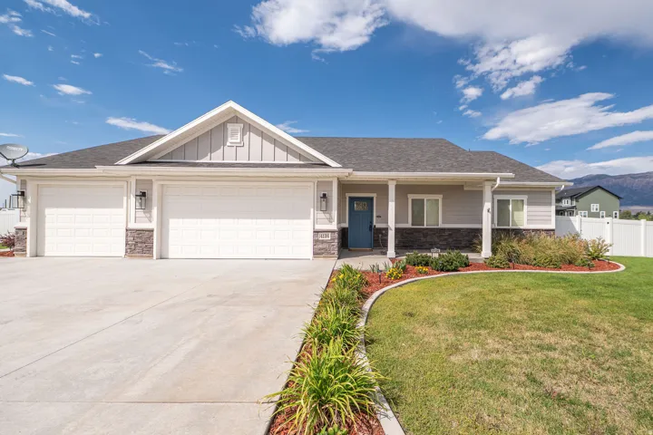 Siding exterior with stone accents, covered front porch, and a three-car garage