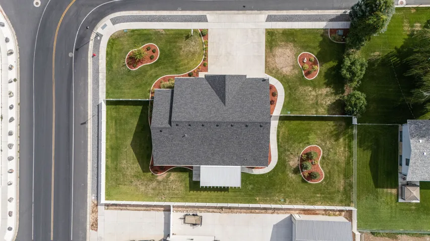 Manicured front yard with mature landscaping, a paved driveway, and established sidewalks