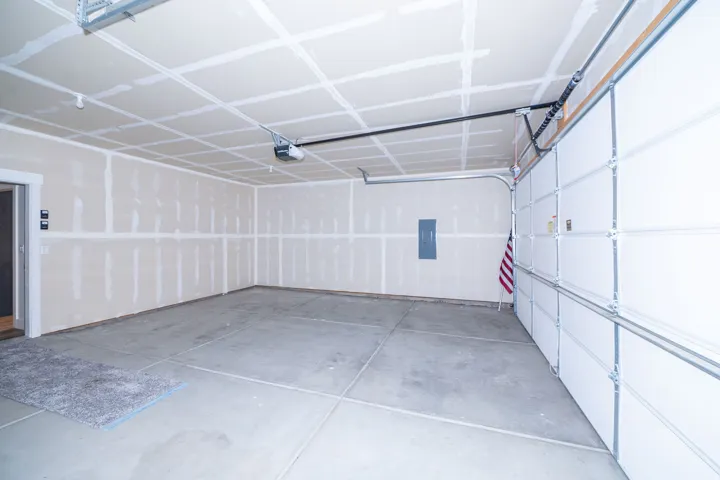 Spacious garage with concrete flooring, automatic garage door opener, and interior access