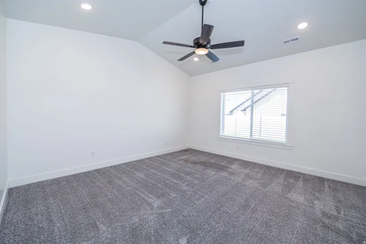 Vaulted ceiling with a contemporary ceiling fan, recessed lighting, and a large window with blinds
