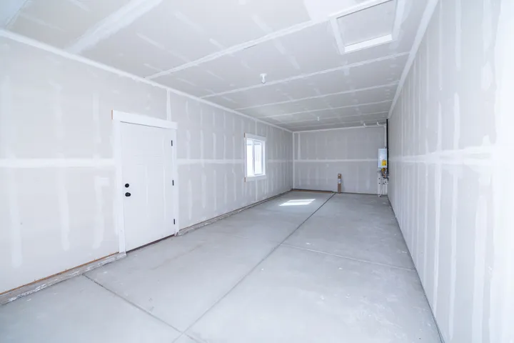 Spacious interior with concrete flooring and a white paneled door