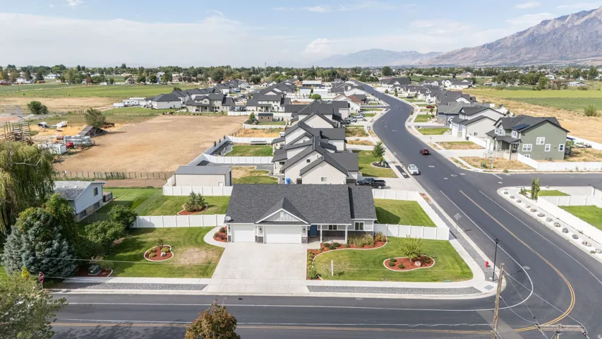 Aerial perspective of a developed neighborhood featuring residential properties with manicured lawns and paved streets