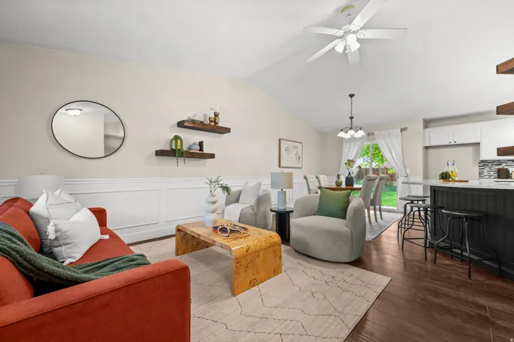 Vaulted ceiling, ceiling fan, wainscoting, wood-finish flooring, white cabinetry