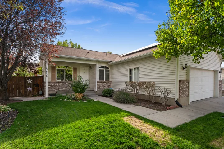 Exterior featuring siding and brick accents, an arched window, an attached two-car garage, and a concrete walkway