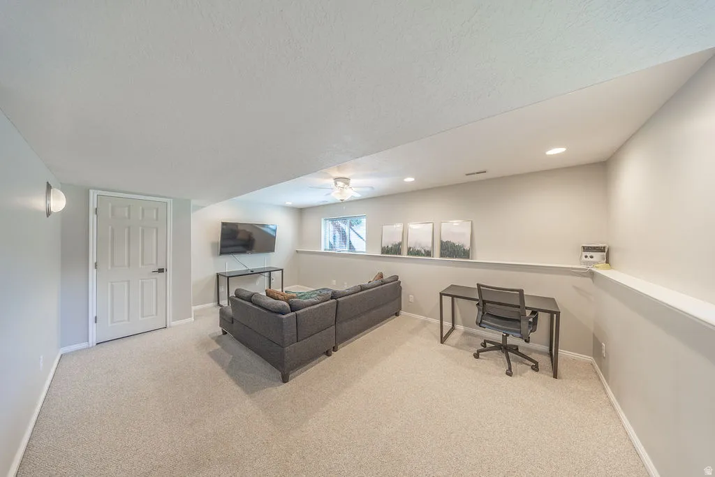 Recessed lighting, wall sconce, light gray wall paint, off-white door, and light-toned carpet