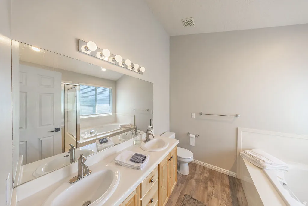 Double vanity with undermount sinks, wood-finish cabinetry, and brushed nickel fixtures