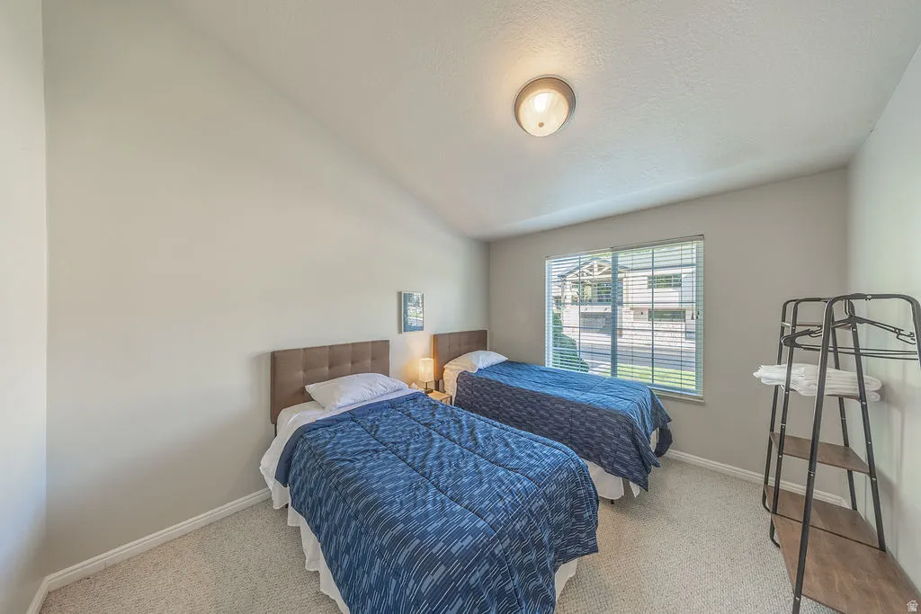 Angled ceiling, recessed lighting, wall-to-wall carpeting, window with blinds