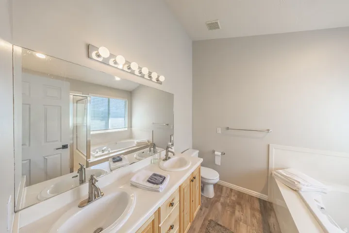 Double vanity with undermount sinks, wood-finish cabinetry, and brushed nickel fixtures