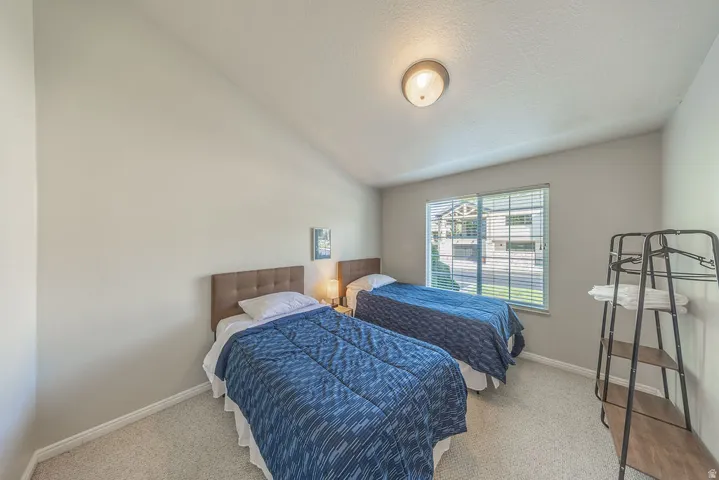 Angled ceiling, recessed lighting, wall-to-wall carpeting, window with blinds