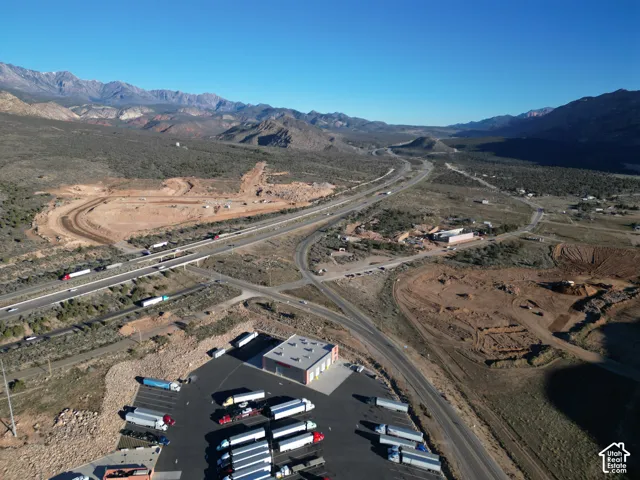 Expansive commercial property featuring multiple structures, a large paved parking area, and direct access to a major highway
