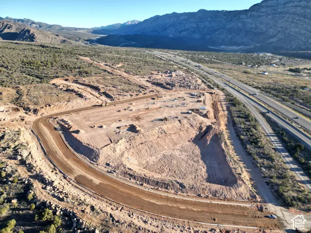 Expansive land development featuring graded terrain, established access roads, and a prominent highway