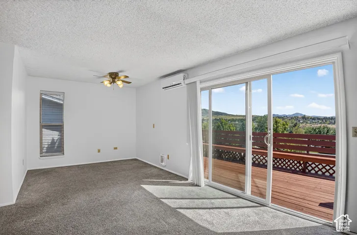 Expansive sliding glass doors opening to a wood-finish deck with a surrounding landscape