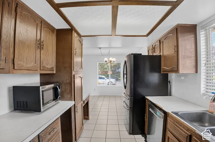 Kitchen featuring wood cabinetry, white countertops, tile flooring, and integrated appliances