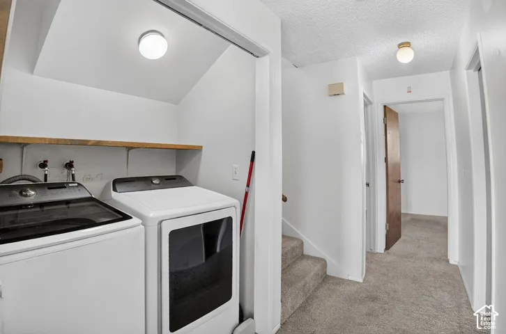 Laundry area with a wood-finish shelf, flush-mount lighting, and carpeted stairs