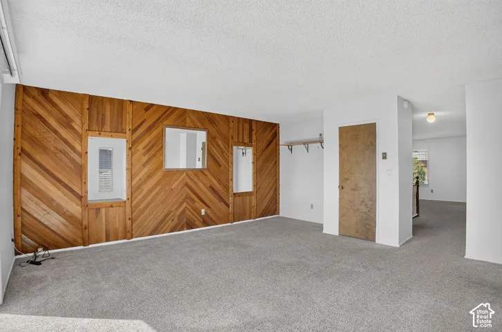 Accent wall featuring diagonal wood paneling and two interior windows