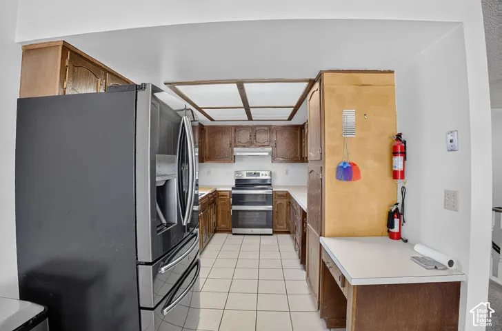 Kitchen featuring wood cabinetry, white countertops, tile flooring, and a coffered ceiling detail