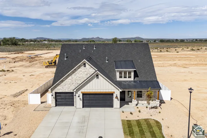 Stone and vertical siding exterior with a dark shingle roof