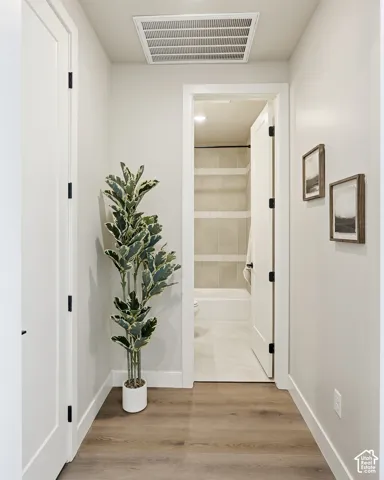 Warm wood-finish flooring complements light-toned walls throughout