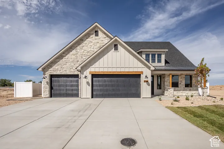 Stone and board-and-batten exterior with a dark shingle roof